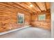 Bedroom with log walls, two windows letting in natural light, and neutral carpet flooring at 25704 Shiloh, Conifer, CO 80433