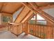 Bedroom with wood-beam ceiling and adjacent room with desk and railing overlooking nature views at 25704 Shiloh, Conifer, CO 80433