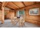 Dining area featuring a charming wooden table, surrounded by rustic log walls and a picturesque view at 25704 Shiloh, Conifer, CO 80433