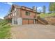 A captivating exterior showing a beautiful log cabin, featuring a garage and adjacent staircase at 25704 Shiloh, Conifer, CO 80433