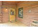 Inviting log cabin shows its wooden front door and rustic details, creating a warm and welcoming entrance at 25704 Shiloh, Conifer, CO 80433
