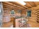 Rustic kitchen featuring log walls, stainless steel appliances, granite countertops, and a charming kitchen island at 25704 Shiloh, Conifer, CO 80433