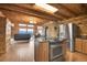 Open kitchen and living room with stone fireplace, stainless steel appliances, and stunning mountain views at 25704 Shiloh, Conifer, CO 80433