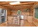 Rustic log kitchen with stainless steel refrigerator, granite countertops, and a kitchen island with seating at 25704 Shiloh, Conifer, CO 80433