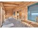 Inviting sunroom featuring wood-paneled walls, tile flooring, and large windows offering picturesque outdoor views at 25704 Shiloh, Conifer, CO 80433