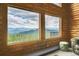 A captivating view from a log cabin window, overlooking lush mountains and forests at 25704 Shiloh, Conifer, CO 80433