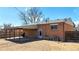 Home's backyard featuring a brick exterior, covered patio, and well-kept landscaping at 7818 Florado St, Denver, CO 80221