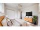 Bright bedroom with hardwood floors, a large window, a dresser, and a plant at 7818 Florado St, Denver, CO 80221