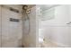 Bathroom shower with neutral tile, shower head, and built-in storage shelves. Additional partial bathroom visible at 7818 Florado St, Denver, CO 80221
