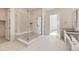 Bright bathroom featuring a glass shower with bench, modern fixtures and tile flooring at 3953 Treadway Pt, Castle Rock, CO 80108