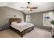 Spacious bedroom featuring a ceiling fan, two large windows, and a wood-framed bed, creating a serene retreat at 8105 E Bayaud Ave, Denver, CO 80230