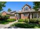 Inviting two-story home featuring a brick facade, well-maintained landscaping, and covered porch at 8105 E Bayaud Ave, Denver, CO 80230