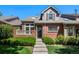 Attractive townhome featuring brick accents, a covered entry, and well-maintained landscaping at 8105 E Bayaud Ave, Denver, CO 80230