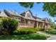 Charming townhome with a brick facade, covered porch, and lush landscaping at 8105 E Bayaud Ave, Denver, CO 80230