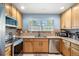 Bright kitchen featuring wood cabinets, granite countertops, stainless steel appliances, and ample storage at 8105 E Bayaud Ave, Denver, CO 80230