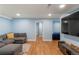 Spacious living room with a comfortable sectional sofa, wood floors, and a television, perfect for relaxation and entertainment at 8105 E Bayaud Ave, Denver, CO 80230