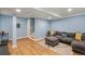 Inviting living room featuring a large sectional sofa, bright paint, and stylish decor with wood-look flooring at 8105 E Bayaud Ave, Denver, CO 80230