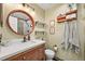 Stylish bathroom featuring a wood vanity, oval mirror, and tiled walk-in shower at 3835 Shefield Dr, Broomfield, CO 80020