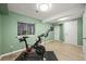Bright exercise room with green walls, laminate flooring, large window, and a Peloton bike for convenient workouts at 3835 Shefield Dr, Broomfield, CO 80020