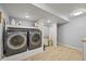 Modern laundry room features front-load washer/dryer, storage shelving, and ample space, offering functionality at 3835 Shefield Dr, Broomfield, CO 80020