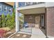 Inviting front porch with brick facade, covered entry, seating, and manicured landscaping at 11216 Uptown Ave, Broomfield, CO 80021