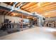 Large basement space with exposed beams and a concrete floor, offering potential for various uses and customization at 7931 W Paine Ave, Lakewood, CO 80235