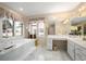 Inviting primary bathroom with garden tub, vanity, and bright natural light at 7931 W Paine Ave, Lakewood, CO 80235