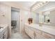 Well-lit bathroom featuring an expansive vanity with dual sinks and a separate toilet room, showcasing a clean and classic style at 7931 W Paine Ave, Lakewood, CO 80235