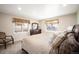 Bright bedroom featuring two windows, a cozy chair, and comfortable bedding creating a serene atmosphere at 7931 W Paine Ave, Lakewood, CO 80235