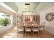 Elegant dining room featuring a modern chandelier, hardwood floors, and a large window with natural light at 7931 W Paine Ave, Lakewood, CO 80235