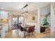 Dining room with hardwood floors, modern pendant lighting, and easy access to the kitchen and outdoor patio at 7931 W Paine Ave, Lakewood, CO 80235