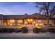 Charming single-story brick home with meticulous landscaping, warm lighting, and inviting front entrance at dusk at 7931 W Paine Ave, Lakewood, CO 80235