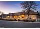 A brick home with a brown tile roof is enhanced by a manicured front yard at dusk at 7931 W Paine Ave, Lakewood, CO 80235