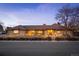 Well lit home featuring warm lighting, a brick facade, and mature landscaping at 7931 W Paine Ave, Lakewood, CO 80235