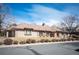 Single-story brick home featuring a three-car garage, mature landscaping, and a well-maintained front lawn at 7931 W Paine Ave, Lakewood, CO 80235