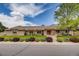 Well-maintained single-story brick home with a three-car garage, mature trees, and a landscaped front yard at 7931 W Paine Ave, Lakewood, CO 80235