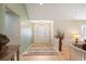 Bright foyer with light hardwood floors, a decorative glass door, and neutral wall colors at 7931 W Paine Ave, Lakewood, CO 80235