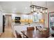 Bright kitchen with granite countertops, white cabinets, stainless steel appliances, and hardwood floors at 7931 W Paine Ave, Lakewood, CO 80235