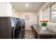 Practical laundry room with stainless steel appliances, counter space, and a window for natural light at 7931 W Paine Ave, Lakewood, CO 80235