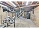 Unfinished basement space offering exposed wooden beams and ductwork with a stairway and raw concrete flooring at 2096 S Logan St, Denver, CO 80210