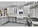 Open-concept kitchen features white cabinetry, stainless steel appliances, and farmhouse sink at 2096 S Logan St, Denver, CO 80210