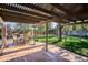 Cozy back patio under pergola, perfect for outdoor dining and relaxation with lush lawn and mature trees at 7866 S Valentia Way, Centennial, CO 80112