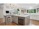 Kitchen island with quartz countertop, gray cabinetry, wine cooler and bar stool seating at 7866 S Valentia Way, Centennial, CO 80112