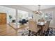 Bright living room with open floor plan, wood floors, and a modern light fixture over the dining table at 7866 S Valentia Way, Centennial, CO 80112