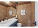Stylish powder room with decorative wallpaper, a modern sink, and a wooden-framed mirror at 7866 S Valentia Way, Centennial, CO 80112
