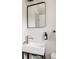 Bathroom featuring a modern sink with a black faucet, a mirror, and white walls at 3540 Everett St, Wheat Ridge, CO 80033
