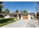 Ranch style home with white painted brick, updated front door and modern garage door at 3540 Everett St, Wheat Ridge, CO 80033
