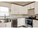 Modern kitchen featuring stainless steel appliances, white cabinetry, and sleek countertops at 3540 Everett St, Wheat Ridge, CO 80033