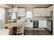 Beautiful kitchen with stainless steel appliances, white cabinets, and a cozy dining area is move-in ready at 3540 Everett St, Wheat Ridge, CO 80033