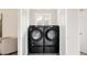 Modern laundry room featuring sleek, black Samsung washer and dryer set with convenient storage pedestals at 3540 Everett St, Wheat Ridge, CO 80033